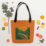 Flat lay of the spacious Nine Arches Whistle Tote Bag next to a book and glasses.